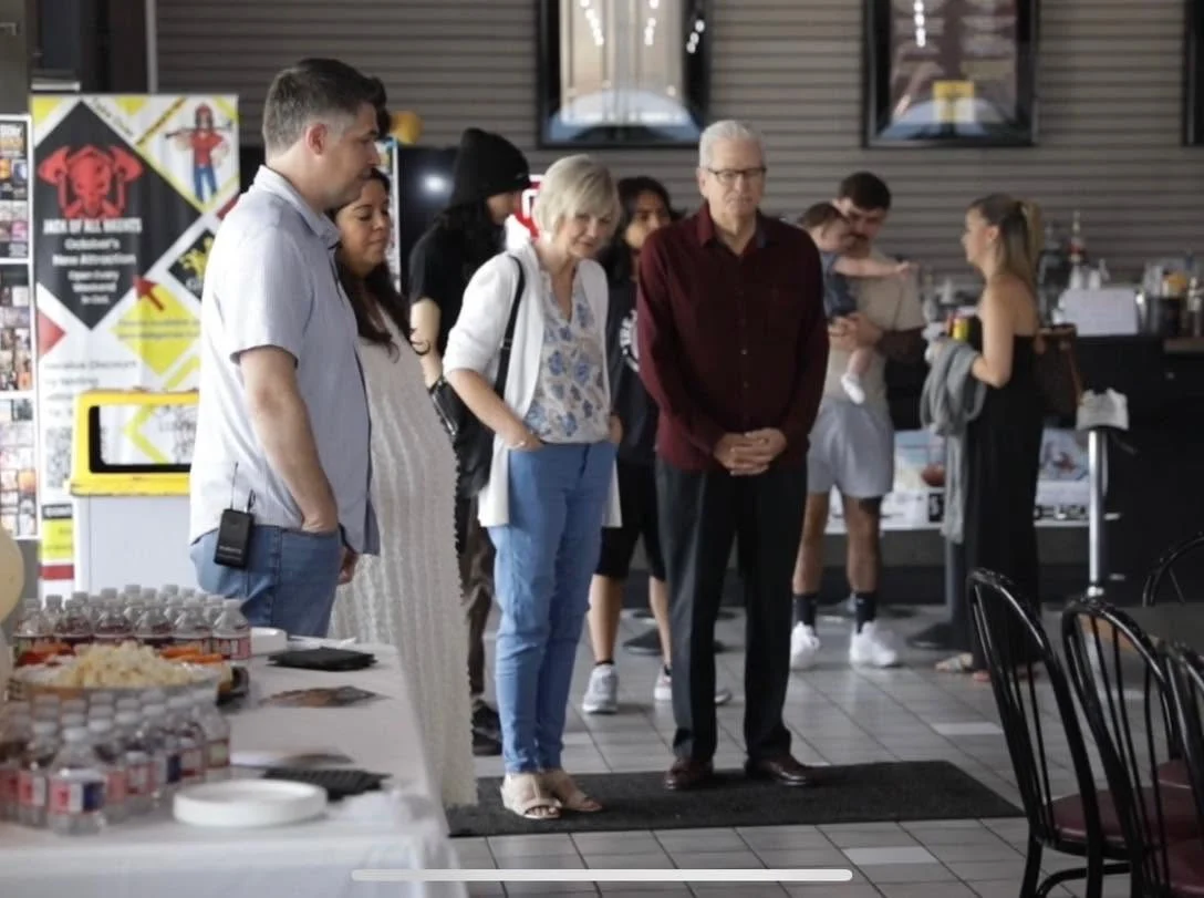 Chris and Nancy Wagoner and church members joining in prayer before a shared meal
